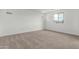 Spacious bedroom with neutral carpet, white walls, and a large window offering natural light at 18383 W Monte Lindo Ln, Surprise, AZ 85387