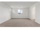 Bright, carpeted bedroom with white walls and a view to the outside at 18383 W Monte Lindo Ln, Surprise, AZ 85387