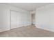 Bright bedroom featuring carpeted floor, white walls, and a large closet at 18383 W Monte Lindo Ln, Surprise, AZ 85387