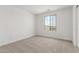 Bright bedroom featuring carpeted floor, white walls, and a large window offering neighborhood views at 18383 W Monte Lindo Ln, Surprise, AZ 85387