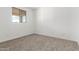 Bright bedroom featuring neutral carpet, a window, and ample natural light, creating a serene atmosphere at 18383 W Monte Lindo Ln, Surprise, AZ 85387