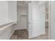 Walk-in closet with built in shelves and hanging rods next to the bathroom at 18383 W Monte Lindo Ln, Surprise, AZ 85387