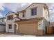 Inviting two-story home showcasing desert landscaping, a two-car garage, and a charming facade with shuttered windows at 18383 W Monte Lindo Ln, Surprise, AZ 85387