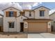 Inviting two-story home showcasing desert landscaping, a two-car garage, and a charming facade with shuttered windows at 18383 W Monte Lindo Ln, Surprise, AZ 85387