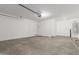 The garage features a clean, concrete floor and a white door leading to the house plus a water heater at 18383 W Monte Lindo Ln, Surprise, AZ 85387