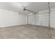 The garage features a clean, concrete floor and a white insulated garage door with an automatic opener at 18383 W Monte Lindo Ln, Surprise, AZ 85387