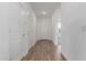 Bright hallway featuring wood-look flooring and access to various rooms, creating a seamless flow throughout the home at 18383 W Monte Lindo Ln, Surprise, AZ 85387