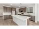 Kitchen features stainless appliances, gray cabinets, white backsplash, and an island with white countertop at 18383 W Monte Lindo Ln, Surprise, AZ 85387