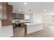 Bright kitchen features stainless appliances, gray cabinets, white backsplash, and an island with white countertop at 18383 W Monte Lindo Ln, Surprise, AZ 85387
