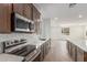 View of a bright kitchen with stainless appliances, gray cabinets, white backsplash, and an island with countertop at 18383 W Monte Lindo Ln, Surprise, AZ 85387