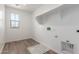 A well lit laundry room is equipped with all the needed hookups at 18383 W Monte Lindo Ln, Surprise, AZ 85387