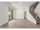 Spacious living area with hard wood flooring, stairway access, and natural light at 18383 W Monte Lindo Ln, Surprise, AZ 85387