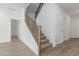 Elegant staircase featuring carpeted steps, wood banister, and natural light, adding sophistication to the home's interior at 18383 W Monte Lindo Ln, Surprise, AZ 85387