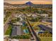 Stunning aerial view of a neighborhood featuring lush landscaping, swimming pools, and mountain views at 1911 E Claremont St, Phoenix, AZ 85016