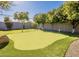 Backyard putting green with trees, grass and a gravel walking path at 1911 E Claremont St, Phoenix, AZ 85016