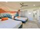 Bright bedroom with two beds, a ceiling fan, and a colorful mural for a cheerful atmosphere at 1911 E Claremont St, Phoenix, AZ 85016