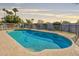 Sparkling in-ground pool surrounded by a tan stone deck and lush landscaping at 1911 E Claremont St, Phoenix, AZ 85016
