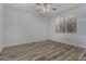 Bedroom with wood-look tile flooring, ceiling fan, and large window at 19963 N Window Rock Dr, Surprise, AZ 85374