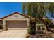 Charming home with a two-car garage, desert landscaping, and a beautiful mature shade tree at 19963 N Window Rock Dr, Surprise, AZ 85374