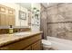 Bathroom with granite countertops, tiled shower and tub combination, and decorative shelving at 2231 E Weldon Ave, Phoenix, AZ 85016