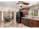 Open eat-in kitchen features wood cabinets, granite counters, tile floors, and black stainless steel refrigerator at 2231 E Weldon Ave, Phoenix, AZ 85016