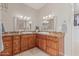 Bathroom with dual sinks, granite countertops, and wood cabinets at 2254 E Becker Ln, Phoenix, AZ 85028