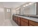 Bathroom with double sinks, wood cabinets, and well-lit mirrors at 2254 E Becker Ln, Phoenix, AZ 85028