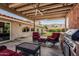 Relaxing covered patio with outdoor kitchen, seating, and view of the manicured backyard at 2254 E Becker Ln, Phoenix, AZ 85028