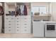 A spacious laundry room features built-in shelves and drawers, and a full-size washer and dryer at 2254 E Becker Ln, Phoenix, AZ 85028