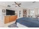 The primary bedroom has a ceiling fan, built-in shelves, a tv, and an ensuite bath at 2254 E Becker Ln, Phoenix, AZ 85028
