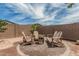 Cozy backyard features Adirondack chairs around a fire pit, with string lights, perfect for relaxing evenings at 23068 E Stacey Rd, Queen Creek, AZ 85142