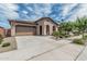 Lovely desert home featuring a two-car garage, mature landscaping, and charming curb appeal at 23068 E Stacey Rd, Queen Creek, AZ 85142