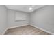 Empty bedroom featuring ceiling fan, wood-look floors, and a window with blinds at 2337 E Riviera Dr, Tempe, AZ 85282