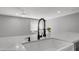 Close-up of a modern kitchen with a white farmhouse sink and a stylish black faucet at 2337 E Riviera Dr, Tempe, AZ 85282