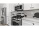 Modern kitchen featuring stainless steel appliances, white cabinets, and elegant countertops at 2337 E Riviera Dr, Tempe, AZ 85282