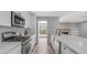 Modern kitchen showcasing white cabinets, a stainless steel range, and access to the backyard at 2337 E Riviera Dr, Tempe, AZ 85282