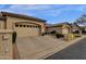 Beige home exterior with a three-car garage, neatly trimmed landscaping and the American flag waving out front at 23705 S Pleasant Way, Sun Lakes, AZ 85248