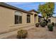 Home's beige exterior featuring well-manicured landscaping, a covered front entryway, and prominent arched windows at 23705 S Pleasant Way, Sun Lakes, AZ 85248