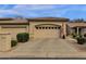 Beige home exterior with a two-car garage, neatly trimmed landscaping and the American flag waving out front at 23705 S Pleasant Way, Sun Lakes, AZ 85248