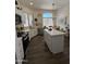 Modern kitchen with white cabinets, stainless steel appliances, and a quartz island for meal preparation and dining at 23705 S Pleasant Way, Sun Lakes, AZ 85248