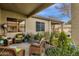 Inviting covered patio space with wicker furniture and lush landscaping, perfect for outdoor relaxation and entertaining at 23705 S Pleasant Way, Sun Lakes, AZ 85248