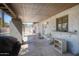 Covered patio featuring a built-in bar, textured walls, and access to the backyard and pool area at 2424 E Ivy St, Mesa, AZ 85213