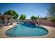 A backyard pool featuring a unique rock waterfall, surrounded by lush greenery, great for summer fun at 2424 E Ivy St, Mesa, AZ 85213
