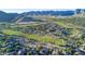 Scenic aerial view of the golf course homes nestled within the lush, green landscape and mountain views at 2701 N Black Rock Rd, Buckeye, AZ 85396
