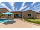 Relaxing backyard with a pool, putting green, and lush tropical landscaping at 2701 N Black Rock Rd, Buckeye, AZ 85396