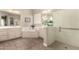 Bright bathroom with soaking tub, glass shower, dual sinks, and tiled floor at 2701 N Black Rock Rd, Buckeye, AZ 85396