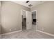 Neutral bedroom featuring an open closet and door to another room, providing space and versatility at 2701 N Black Rock Rd, Buckeye, AZ 85396