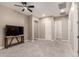 Spacious bonus room features plush carpeting, a ceiling fan, and a modern TV stand at 2701 N Black Rock Rd, Buckeye, AZ 85396