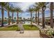 Community pool surrounded by tall palm trees, lounge chairs, and a lush green lawn at 2701 N Black Rock Rd, Buckeye, AZ 85396