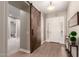 Welcoming entryway with wood-look floors, barn door, and stylish decor at 2701 N Black Rock Rd, Buckeye, AZ 85396